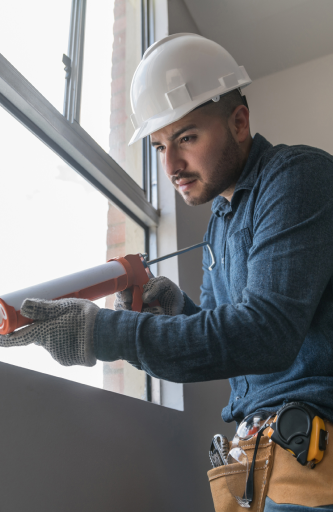 a man caulking a window